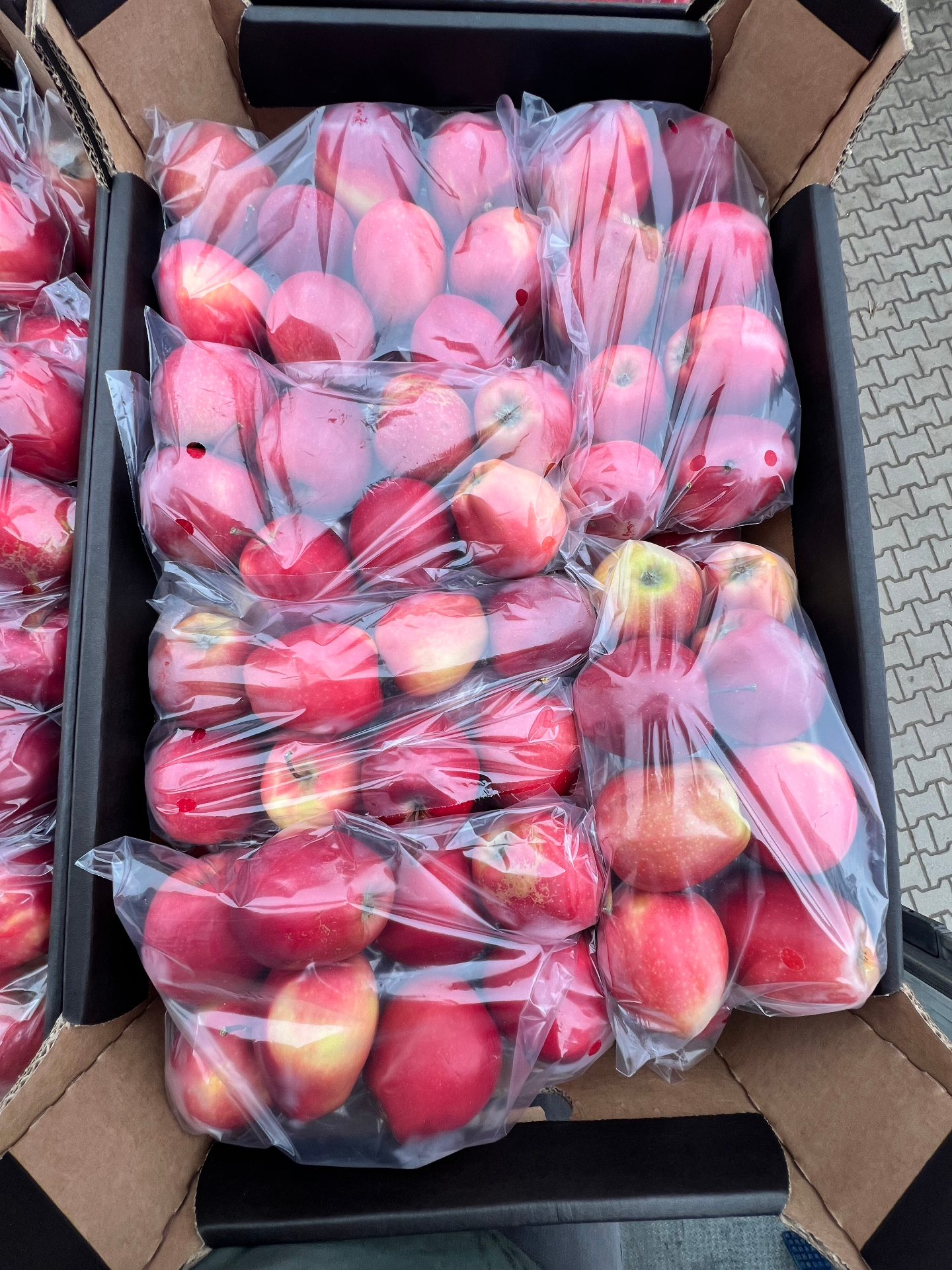 Apples in retail flow-pack bags inside a crate